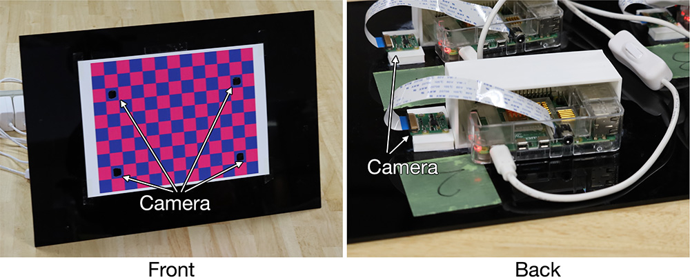 Prototype projector calibration board. A black acrylic board with four embedded cameras mounted through openings in the board.